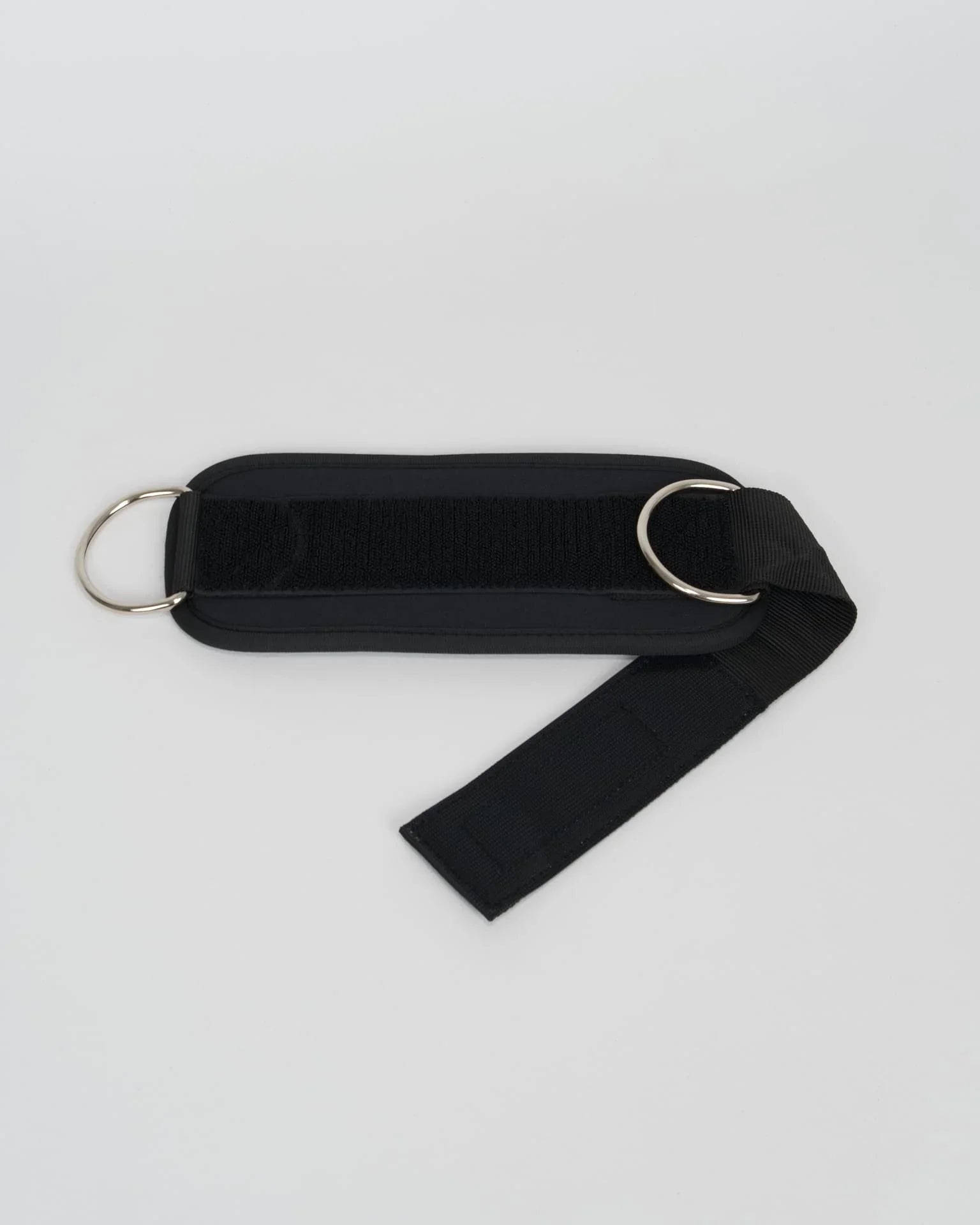 Sangle de cheville STOYIK noire ouverte à plat, avec double anneau métallique et fermeture velcro