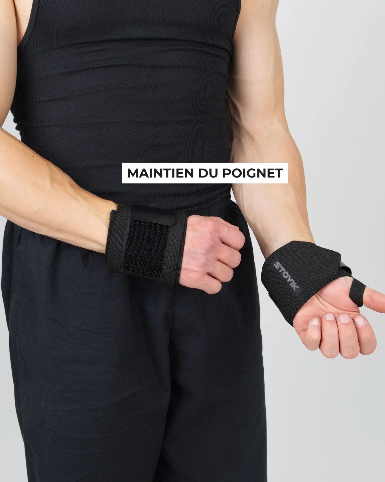 Athlète ajustant les deux bandes de poignets STOYIK noires avant une séance de musculation