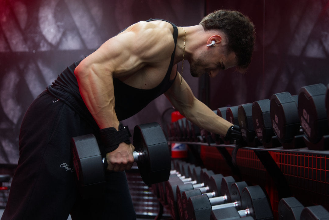 Gros plan sur des sangles de tirage STOYIK Athletics en action lors d'un exercice de rowing en musculation, offrant un soutien optimal à l'avant-bras