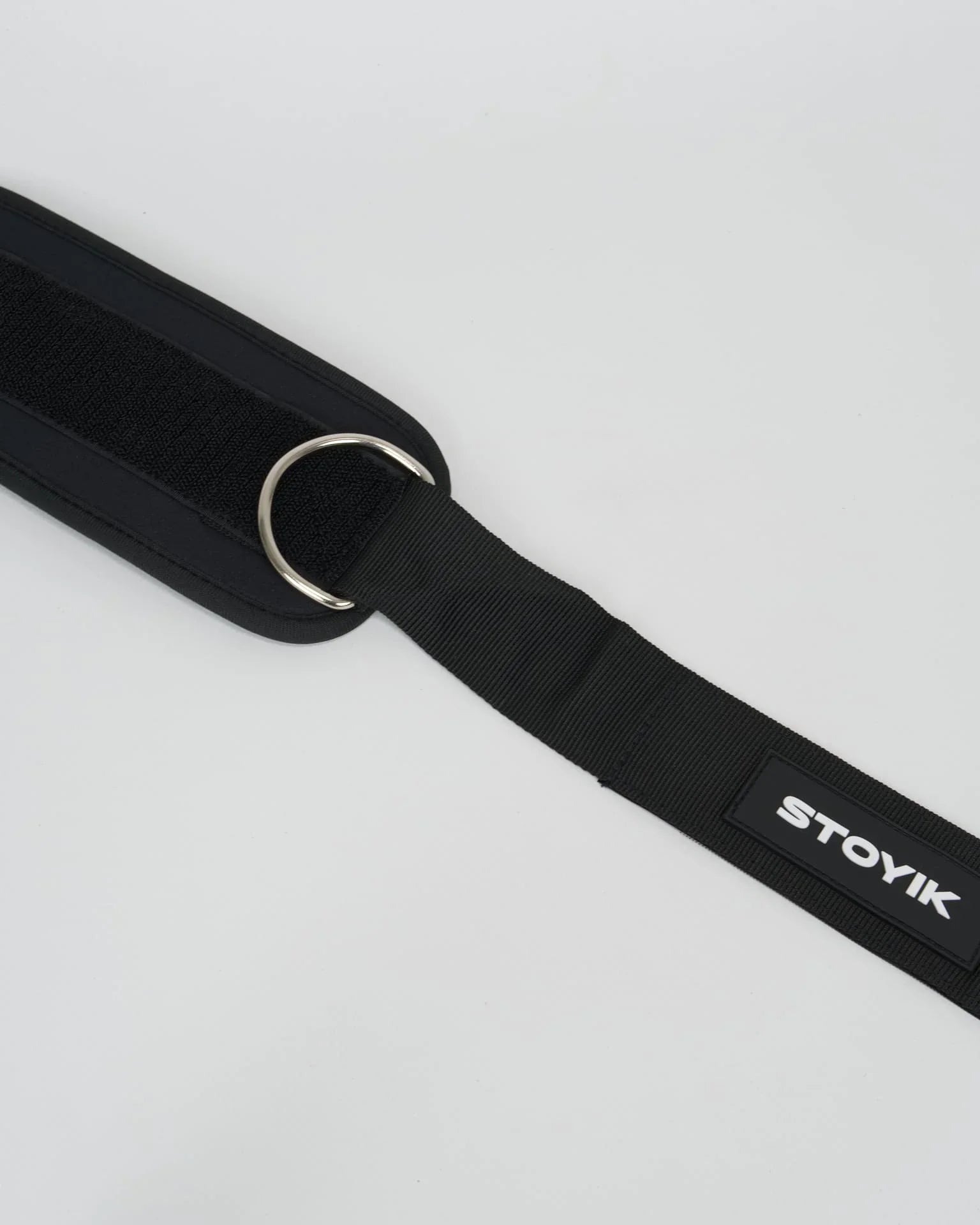 Zoom sur la sangle de cheville STOYIK noire avec anneaux en acier et logo visible