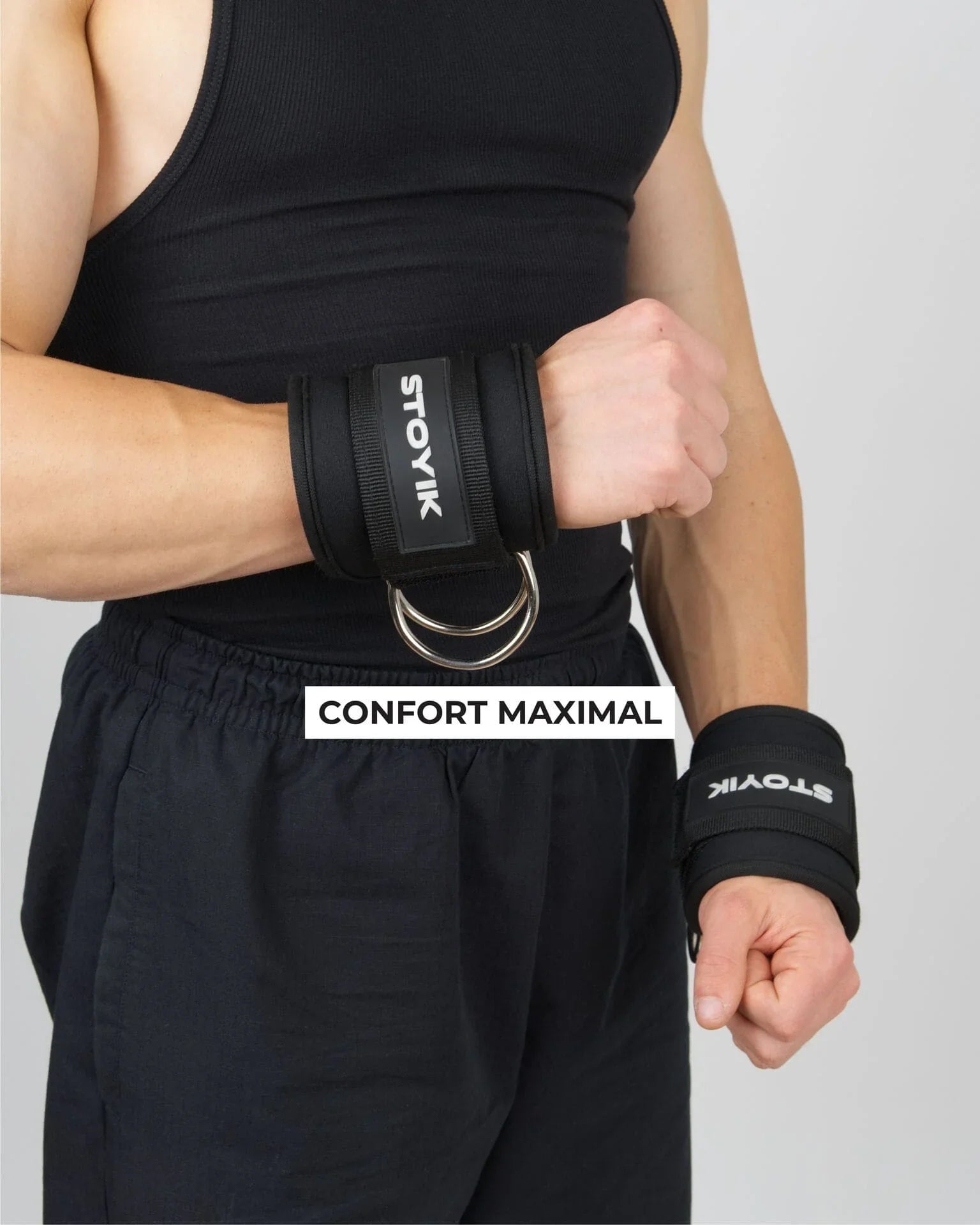 Athlète portant les sangles de cheville STOYIK noires autour des poignets pendant un entraînement de musculation