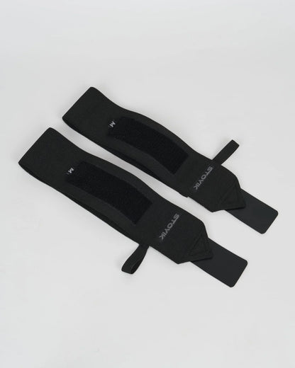 Paire de bandes de poignets de musculation STOYIK noires taille M vue à plat sur fond blanc