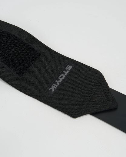 Zoom sur la bande de poignet de musculation STOYIK noire avec logo visible et fermeture velcro