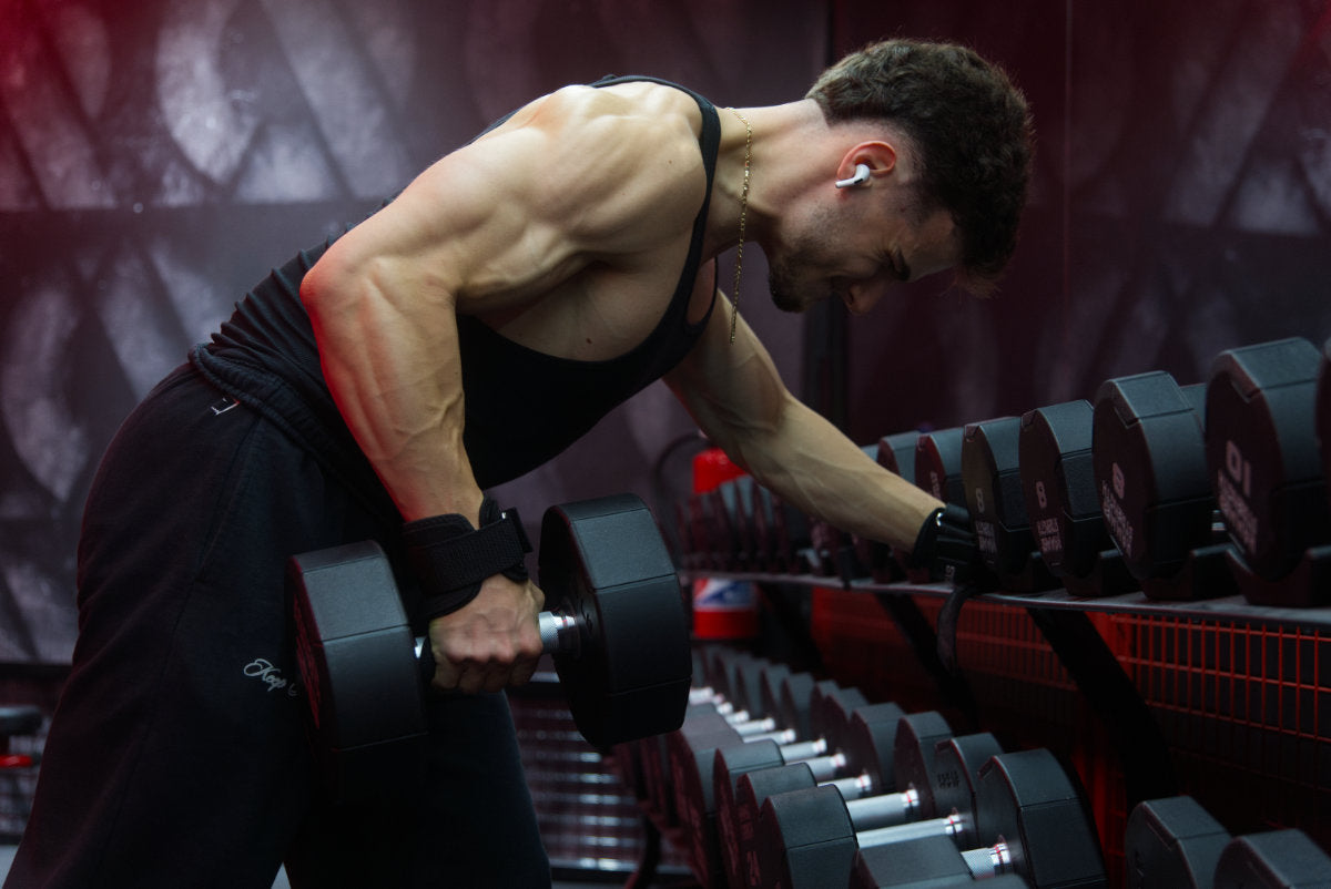 Gros plan sur des sangles de tirage STOYIK Athletics en action lors d'un exercice de rowing en musculation, offrant un soutien optimal à l'avant-bras