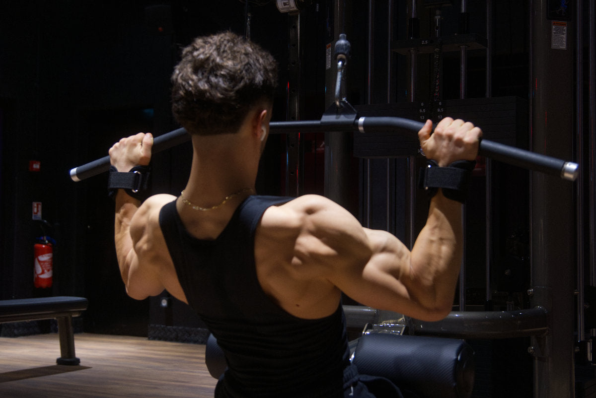 Gros plan sur des mains gantées tenant une barre de musculation avec des sangles de tirage STOYIK Athletics pour améliorer la prise